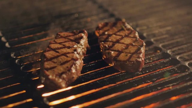 Cooking delicious juicy meat steaks on the grill on fire