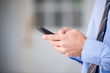 Cropped hand of businessman using mobile phone