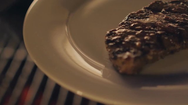 Juicy and delicious piece of grilled meat is removed from the grille