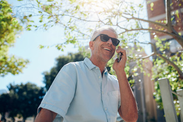 Mature man talking on mobile phone outdoors