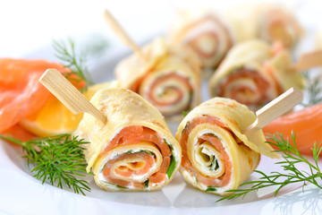 Rouleaux de crêpes au saumon avec fromage à la crème au raifort et feuilles de roquette