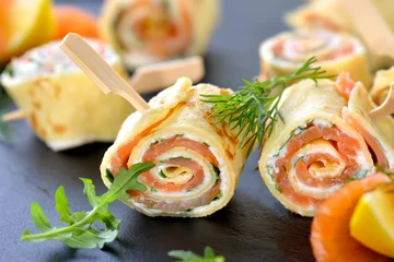 Crédence de cuisine en verre imprimé Buffet, Bar Rouleaux de crêpes au saumon avec fromage à la crème au raifort et feuilles de roquette