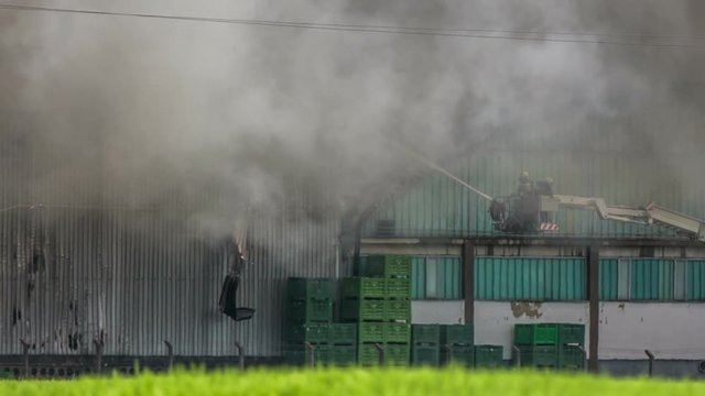 Cloud of smoke cover two fireman extinguishing fire