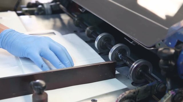 Flexo press surface printing machine in a print flexography factory operator hand