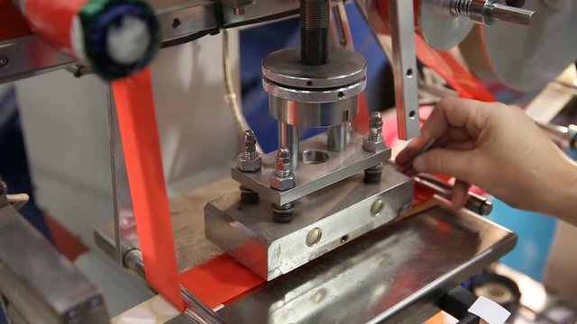 Hot stamping press for printing labels in a red tape ribbon