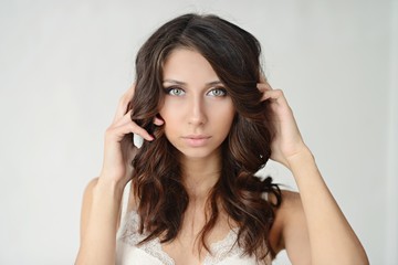 Fototapeta premium Female portrait of cute lady indoors. Close up beautiful sexy model girl in elegant pose. Closeup beauty brunette woman with hairstyle