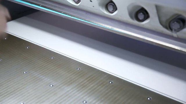 Cutting paper shears cutter guillotine machine in a printing factory