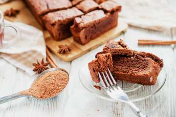 
dessert , chocolate brownie cake with black tea , cinnamon and spices on a wooden background