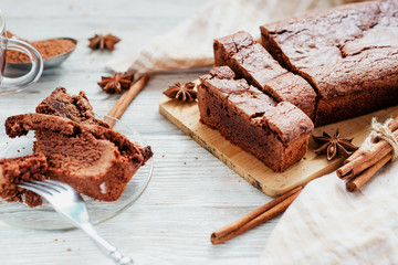 
dessert , chocolate brownie cake with black tea , cinnamon and spices on a wooden background