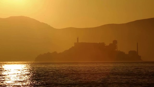 Alcatraz island penitentiary at sunset and backlit in San Francisco