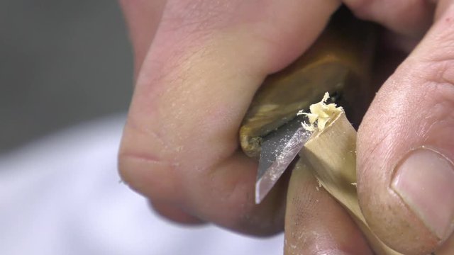 luthier removes a thin layer of wood on the soul of the instrument