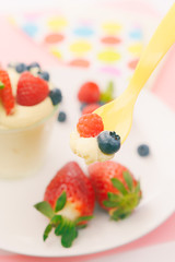 Babylöffel mit Joghurt und Obst gefüllt. Auf den Betrachter zukommend.