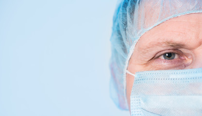 Mature mail surgeon in hospital closeup portrait on blue background