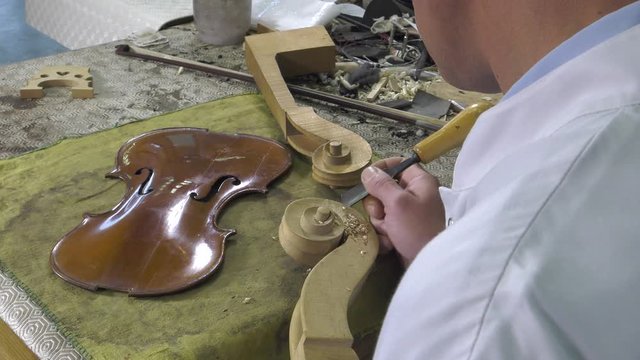 Luthier sculpt a cello head