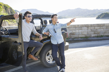 Happy young men and jeep