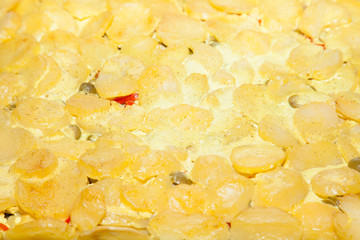 Closeup of baked potatoes with cheese and green olives