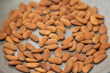 Closeup of roasting raw almonds with selective focus