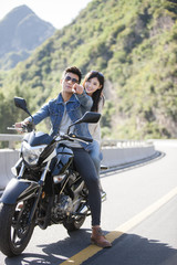 Fototapeta na wymiar Young couple riding motorcycle together