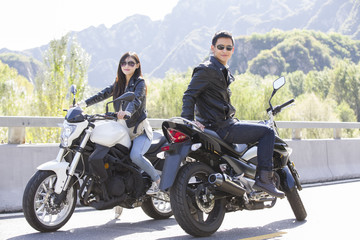 Fototapeta na wymiar Young couple riding motorcycle together