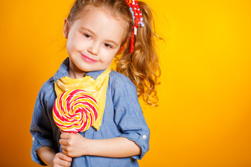 Studio portrait of a beautiful little girl with large Lollipop