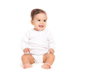 Portrait of a curious little boy,brunette with brown eyes and short hair,dressed in a white shirt and a white diaper,barefoot posing in Studio,sitting on a white background, smiling mouth open