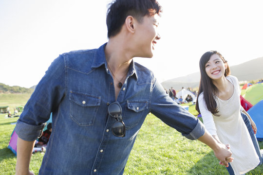 Young couple holding hands on the grass