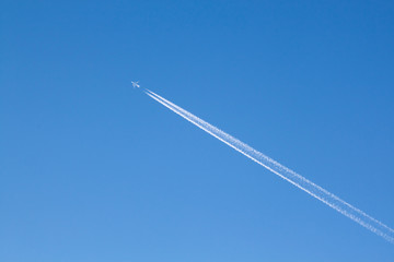 Fernweh - Großes Passagierflugzeug mit Kondensstreifen am blauen Himmel