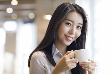 Young woman drinking coffee in caf_