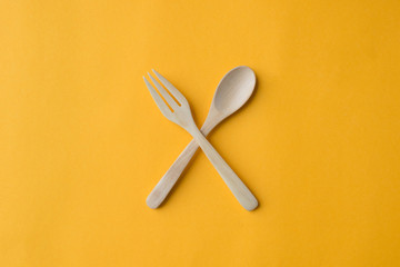 Wooden spoon and fork cross on grey paper background
