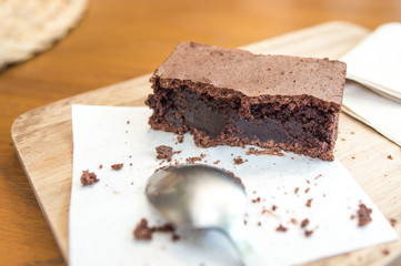 Bitten delicious Chocolate Brownie on wooden tray