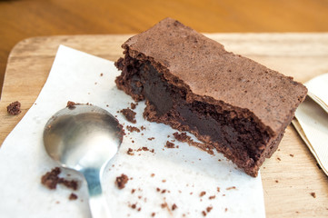 Bitten delicious Chocolate Brownie on wooden tray