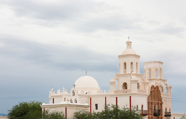 Fototapeta premium Mission San Xavier del Bac on a Cloudy Day. Mission San Xavier del Bac is a historic Spanish Catholic mission located at Tucson, Arizona.