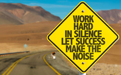 Work Hard in Silence Let Success Make the Noise sign on desert road