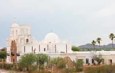  Mission San Xavier del Bac on a Cloudy Day. Mission San Xavier del Bac is a historic Spanish Catholic mission located at Tucson, Arizona.