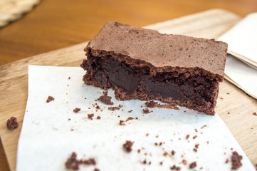Bitten delicious Chocolate Brownie on wooden tray