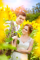 Happy couple on the sunflowers field background.