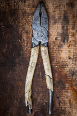 Pliers on wooden plank