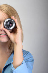 Young Woman Using Camera lens Over Gray Background