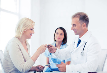 Obraz premium doctor giving tablets to patient in hospital