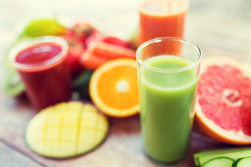 close up of fresh juice glass and fruits on table