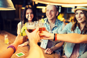 happy friends clinking glasses at bar or pub