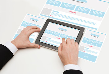 close up of hands with web design on tablet pc