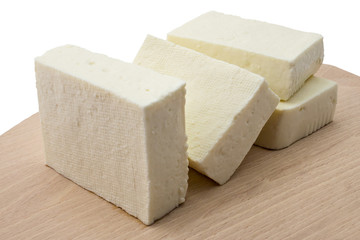 Fresh cheese from cow's milk on wooden plate and white background