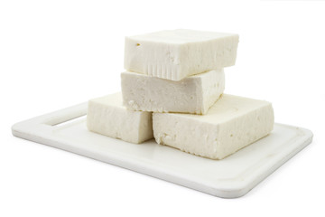 Fresh cheese from cow's milk on white plastic plate and white background