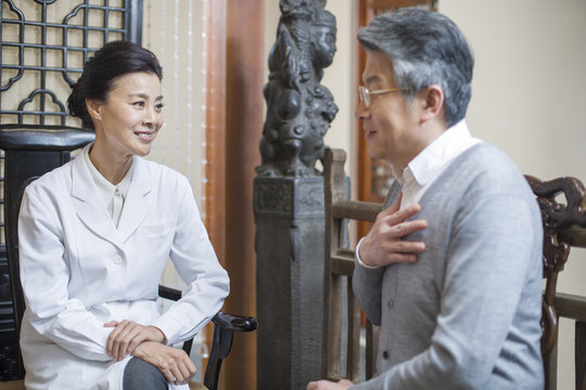 Female Chinese doctor talking with patient