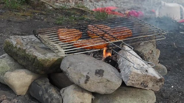 Grill outdoors near the river. Grill made with his own hands made of stone. Grill stone close up on a grid which lies with the meat for the grill.