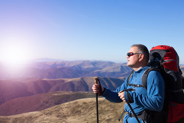 Obraz premium A traveler stands on top of a mountain and looks out to sea.
