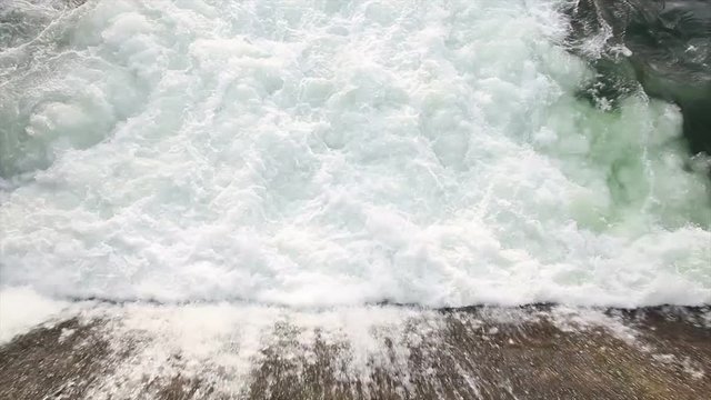 Agua saliendo a borbotones en el punto de evacuacion de una presa o dique de embalse 
