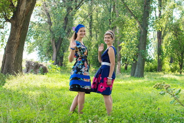  Two beautiful young woman relaxing outdoor. Two girls walking in park. two happy girls in the park for a walk, slight blur.
