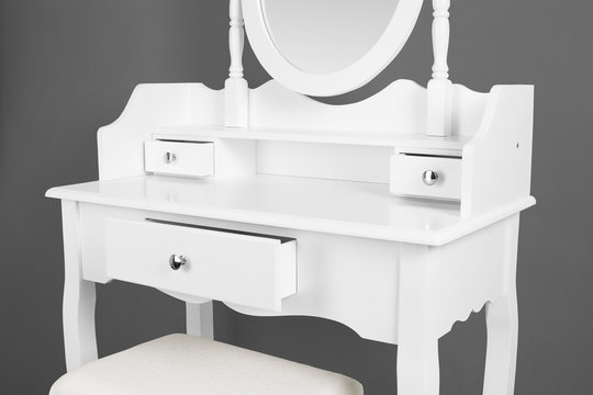 Part of white dressing table on grey background